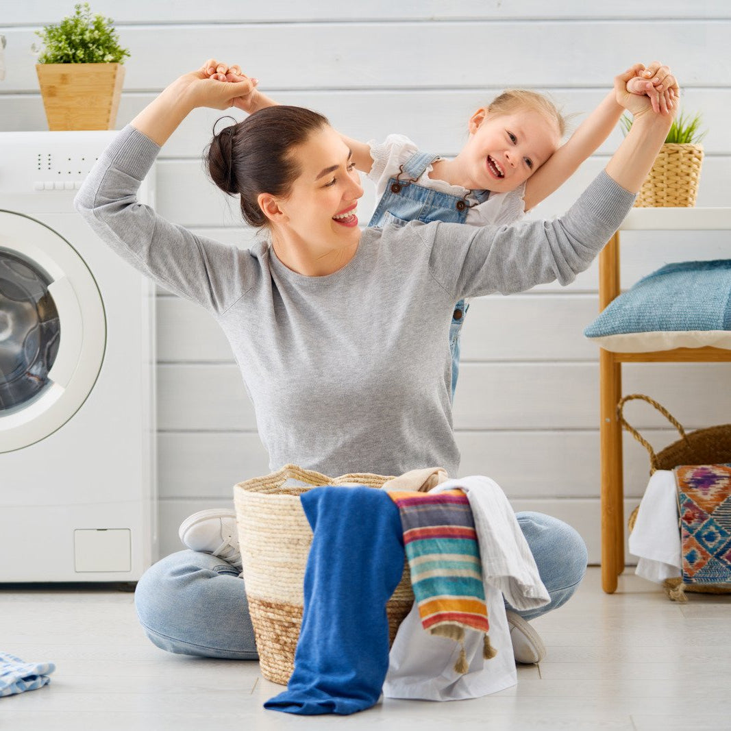 Woman and child in a laundry room with a washing machine.